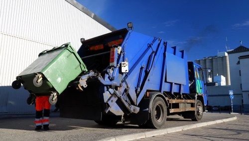 City street in Brixton with commercial waste bins and collection vehicles