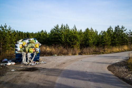 Workers handling commercial waste bins at a collection point
